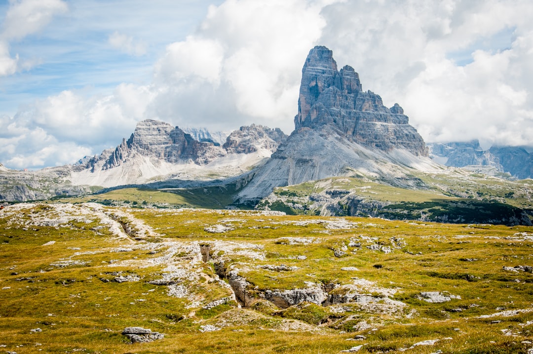 Magic landscape 😊 by Bible Verse Daily rock formation on wide field grass under cloudy blue sky during daytime