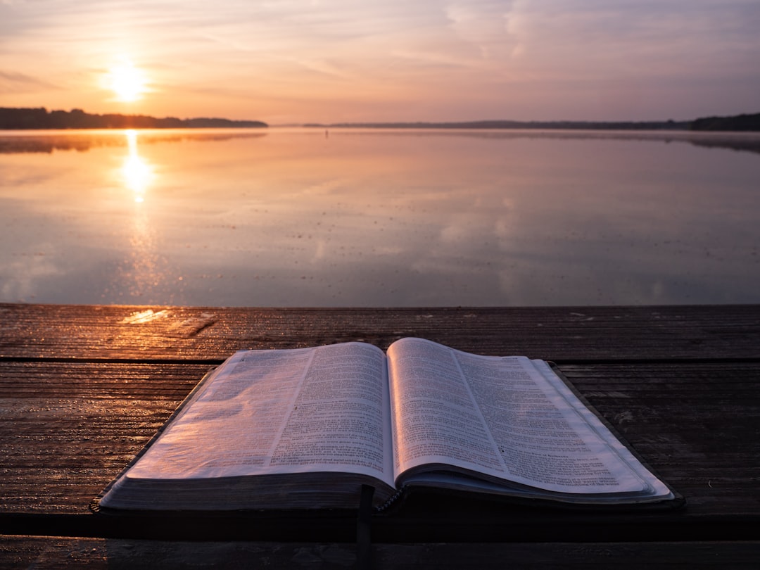Morning Reading by Bible Verse Daily book on top of table and body of water